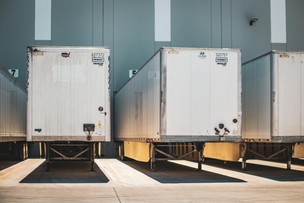 A row of freight trailers parked at a commercial loading dock, emphasizing transportation and logistics.